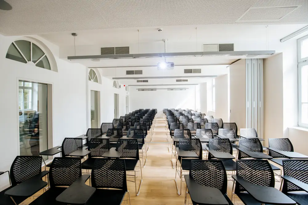Aula moderna con filas de sillas negras y proyector en el Centro Universitario de Formación de la Policía Nacional.