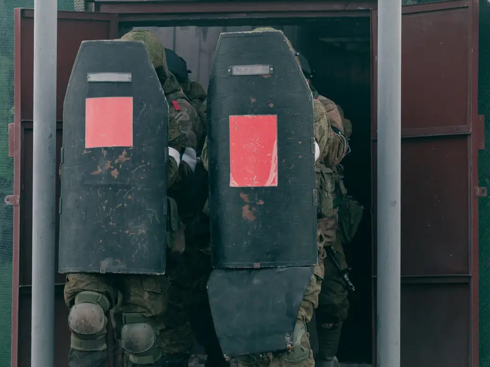 Agentes de unidades especiales con escudos balísticos durante un simulacro en instalaciones de entrenamiento policial.