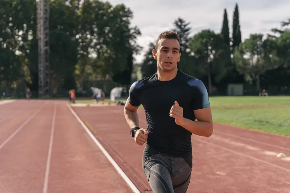 Aspirante a policía corriendo en pista de atletismo durante su entrenamiento para las oposiciones físicas.