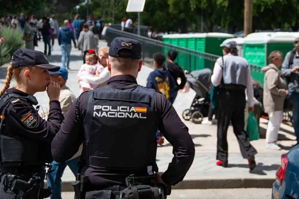 Agentes de la Policía Nacional con uniforme oficial patrullando una calle concurrida durante su servicio de seguridad.