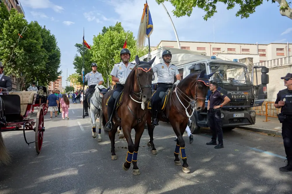 Agentes de la Policía Nacional desfilando a caballo con uniforme oficial durante una ceremonia en la ciudad.