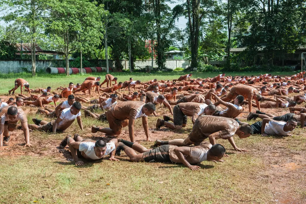 Aspirantes realizan flexiones en el barro durante las pruebas físicas y el entrenamiento para el ingreso en la policía.