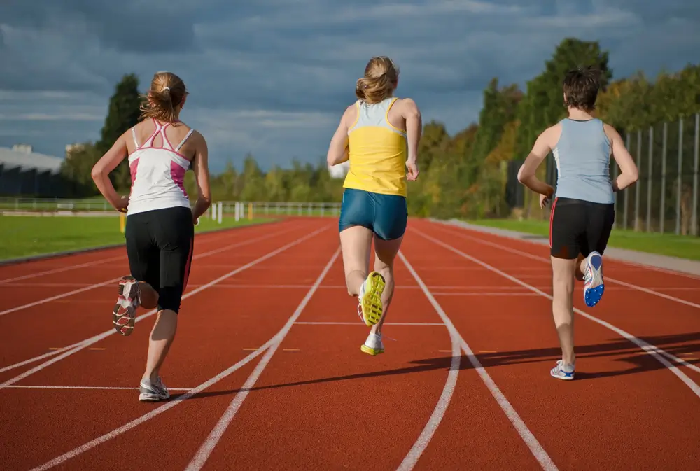 Opositores corriendo en una pista de atletismo durante su entrenamiento físico para las pruebas de policía.