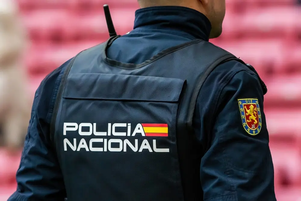 Uniforme de la Policía Nacional con parche de la UIP en el brazo y distintivo oficial en el chaleco táctico.